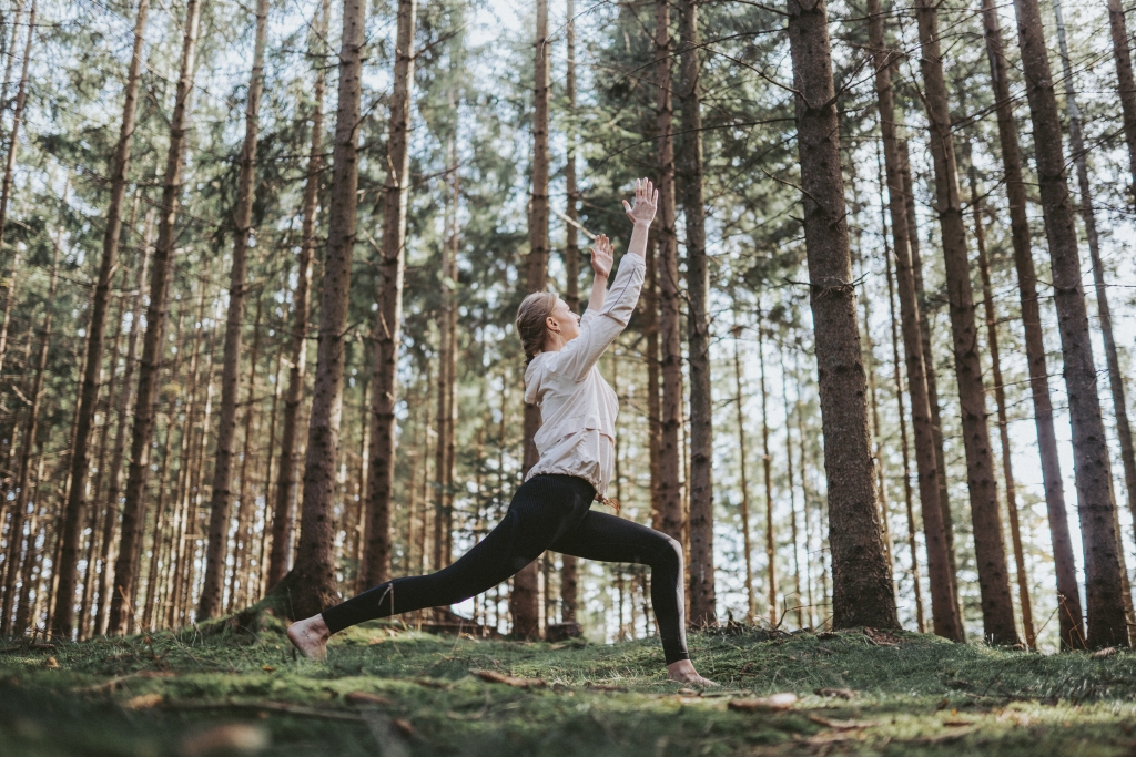 Frau macht Yoga im Wald
