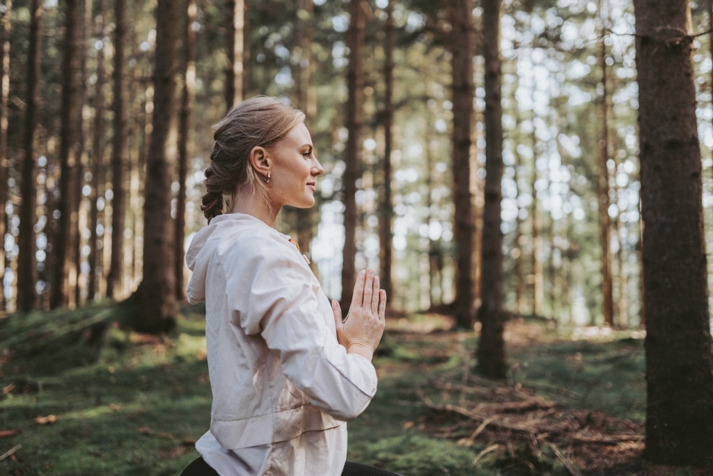 Frau macht Yoga im Wald
